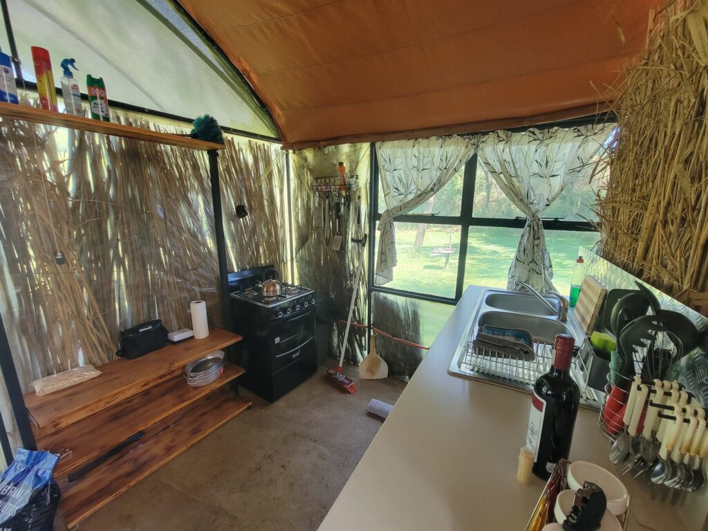Kitchen counter with gas stove and utensils inside the river hut