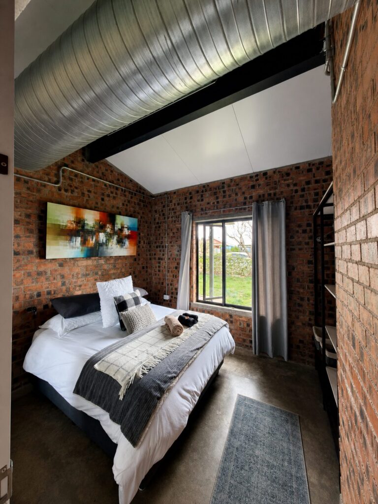Derde slaapkamer by die Vakansie Huis met ’n queenbed en kunswerk daarbo