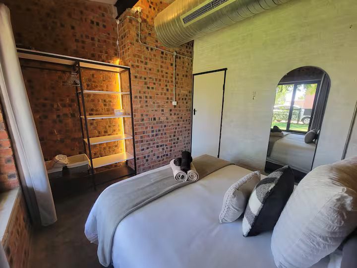 Bedroom with a full-length mirror, arched window and a double bed