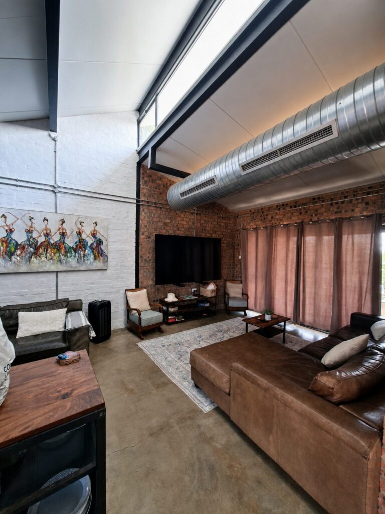 Open-plan lounge with couches and a wall-mounted television at the Vacation Home