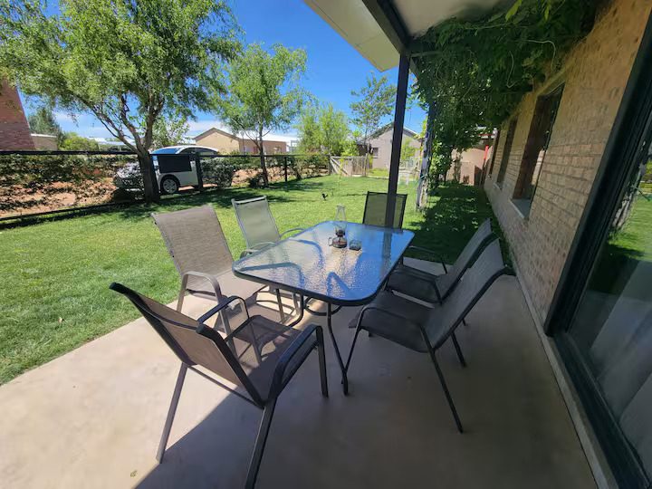Covered patio with a table and chairs looking onto the garden